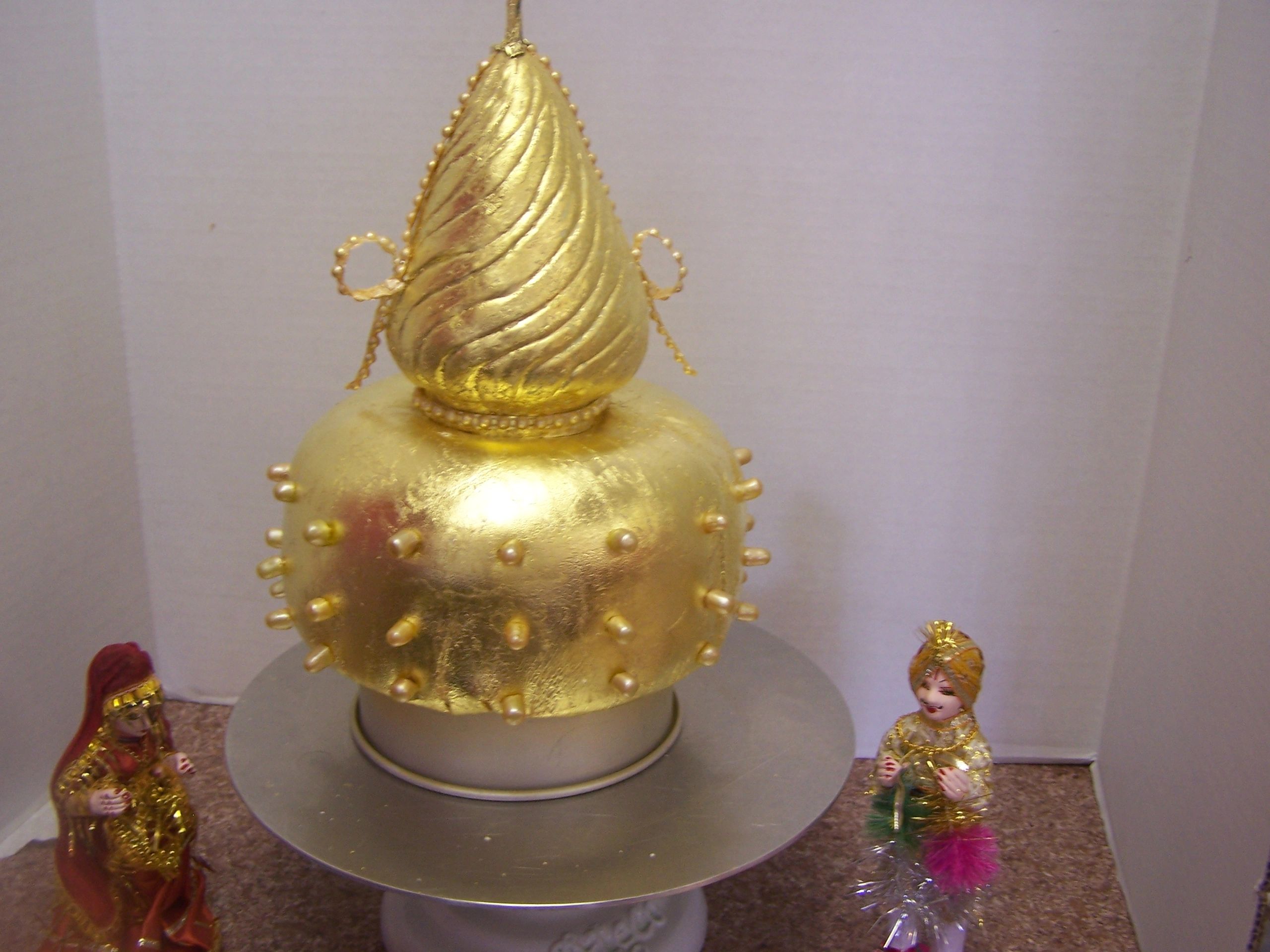 Close up of gold topper on Indian Wedding Cake.
