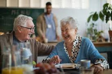 Elderly couple joyfully sharing a meal together at home.