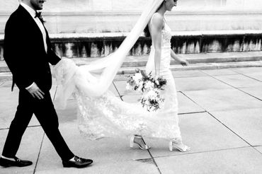 Groom Holding Brides Veil for Newlywed Photos in Downtown Detroit outside of DIA