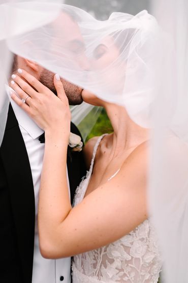 Bride and Groom Kissing Veil Photo in Michigan Wedding