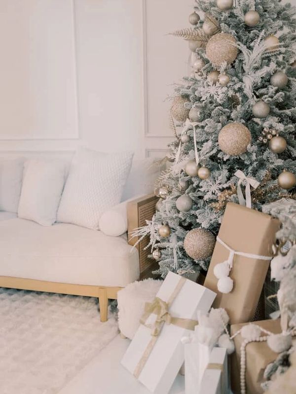 Elegant Christmas tree with gold ornaments beside a cozy white sofa and wrapped gifts. Narrative Studio, Bolton, MA, Mini Sessions