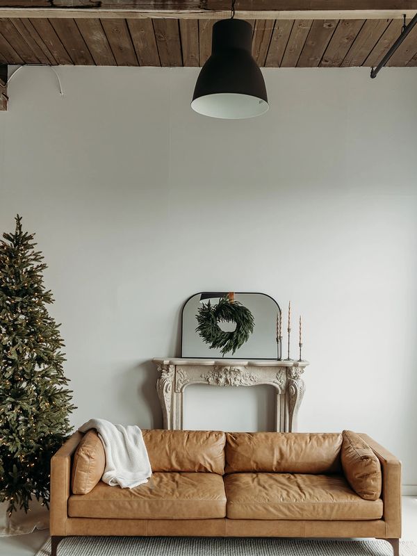 Minimalist living room with leather sofa and Christmas tree.