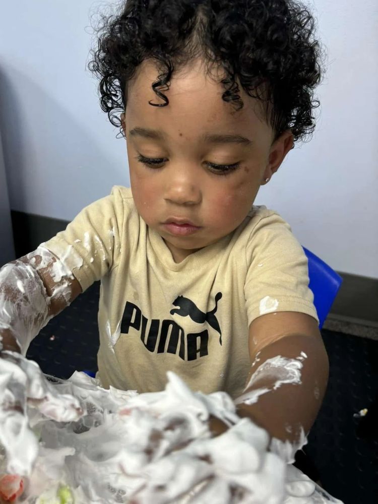 A young child playing with foam, focused on the activity.