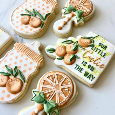 Decorative baby shower themed cookies with orange and green icing.