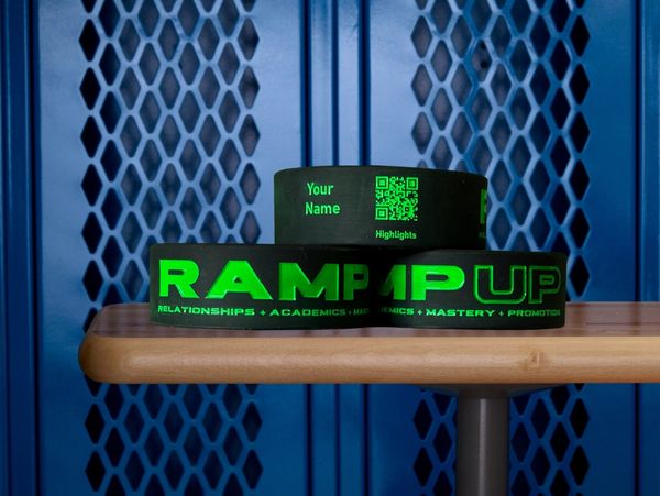 Three black RAMP Sport bands stacked up on bench in a locker room with blue lockers