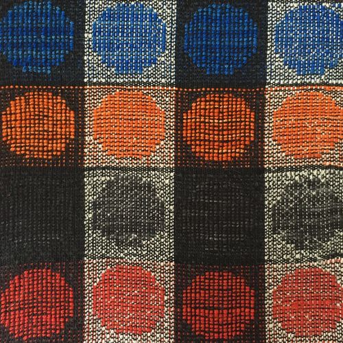 Close-up of handwoven cloth of blue, orange, black & red circles on black & white vertical stripes