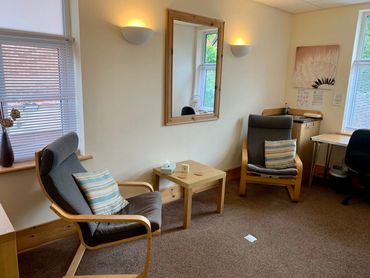 The Sea Holly Room, Magnolia Therapy Centre. Two bentwood armchairs, windows and soft lighting.
