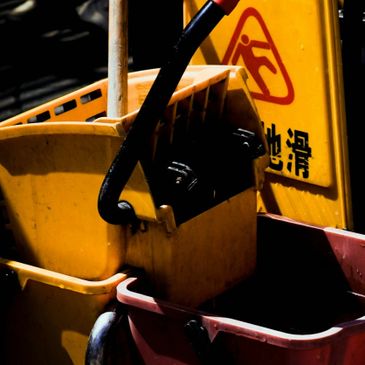 Yellow mop buckets and a wet floor caution sign.