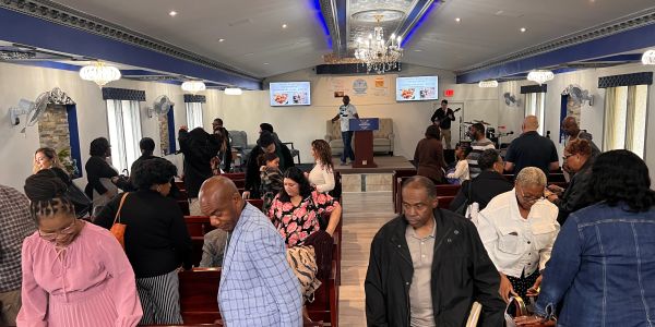Congregants gather inside a church after service, engaging in conversation and fellowship.