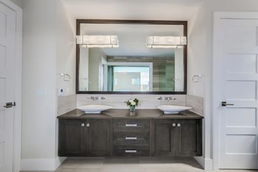Modern bathroom vanity with dual sinks and large mirror.