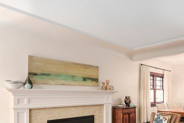 Cozy living room with fireplace, beige sofas, and wooden coffee table.