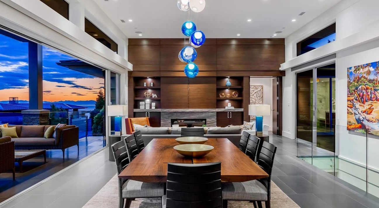 Modern dining room with wooden table and blue pendant lights.