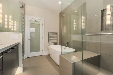 Modern bathroom with a glass shower, freestanding tub, and sleek fixtures.