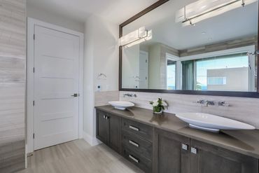 Modern bathroom with double sinks and large mirror.