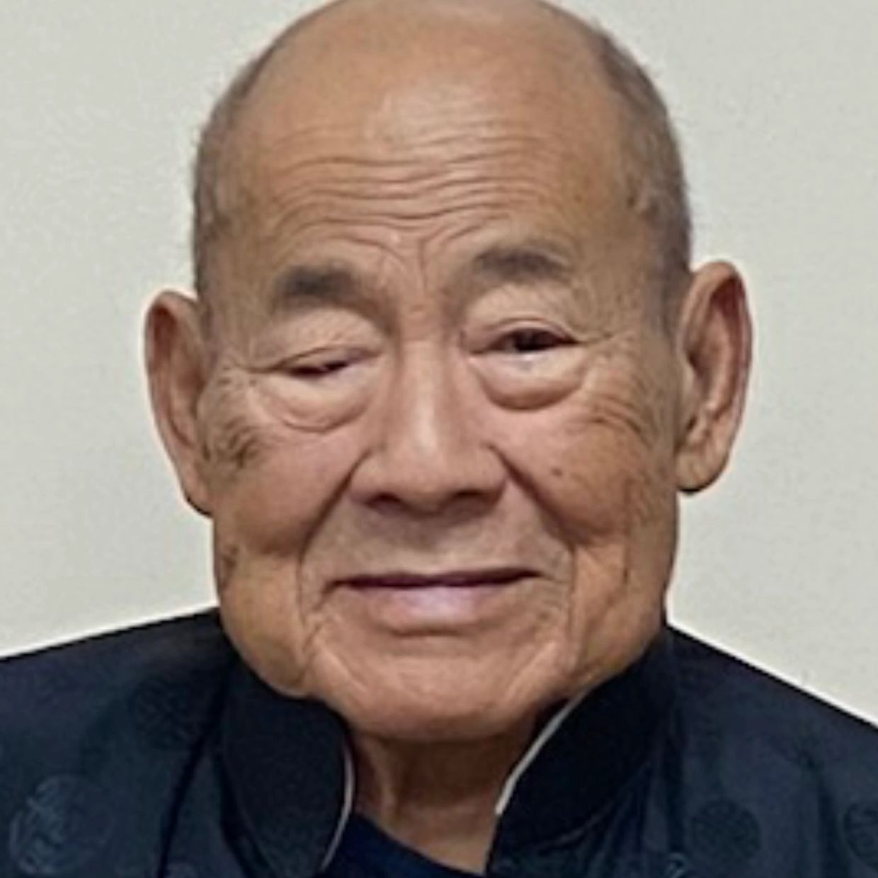 Portrait of an elderly man with a gentle smile.