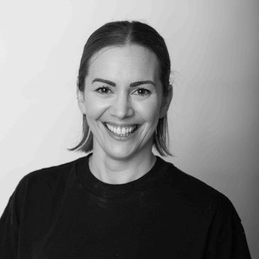 Smiling woman with short hair in a black shirt.