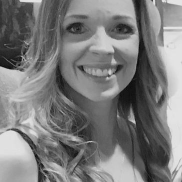 Smiling woman with long hair in black and white photo.