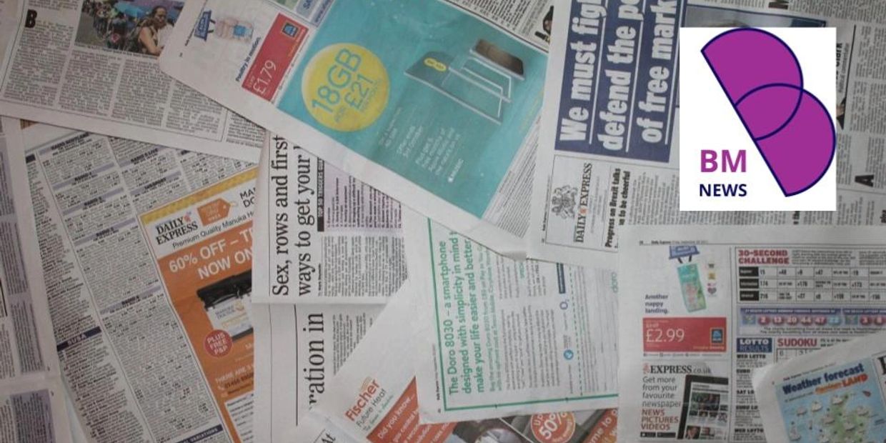 A pile of newspapers with various articles and ads scattered on a surface.