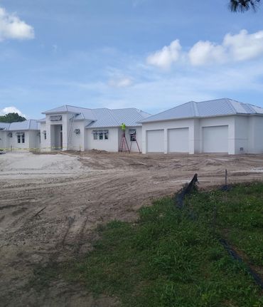 Freshly painted white new-construction home under a blue sky