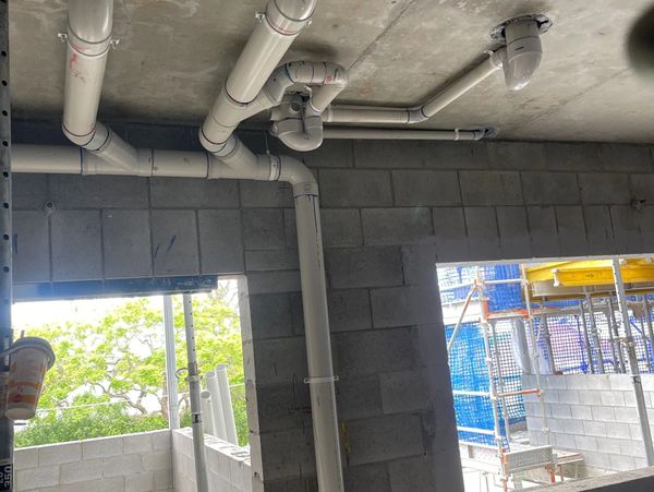 PVC pipes installed on a concrete ceiling in a building under construction.