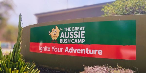 Sign for The Great Aussie Bush Camp inviting adventure.