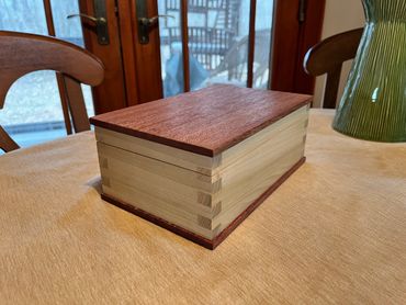 Wooden box on table with box joints, poplar sides, and African mahogany top and bottom