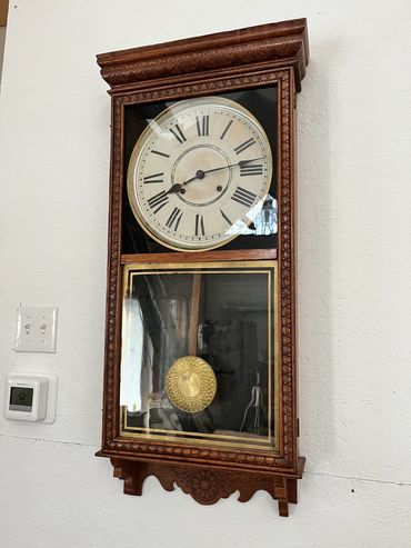 My great grandfather's old Regulator wall clock on a white shop wall.
