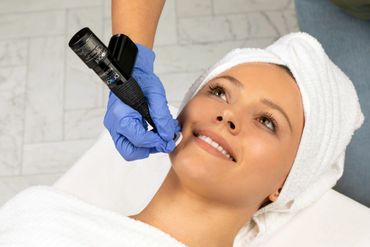 Woman receiving a facial treatment with a skincare device.