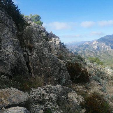 Paisaje montañoso rocoso con cielo azul.
