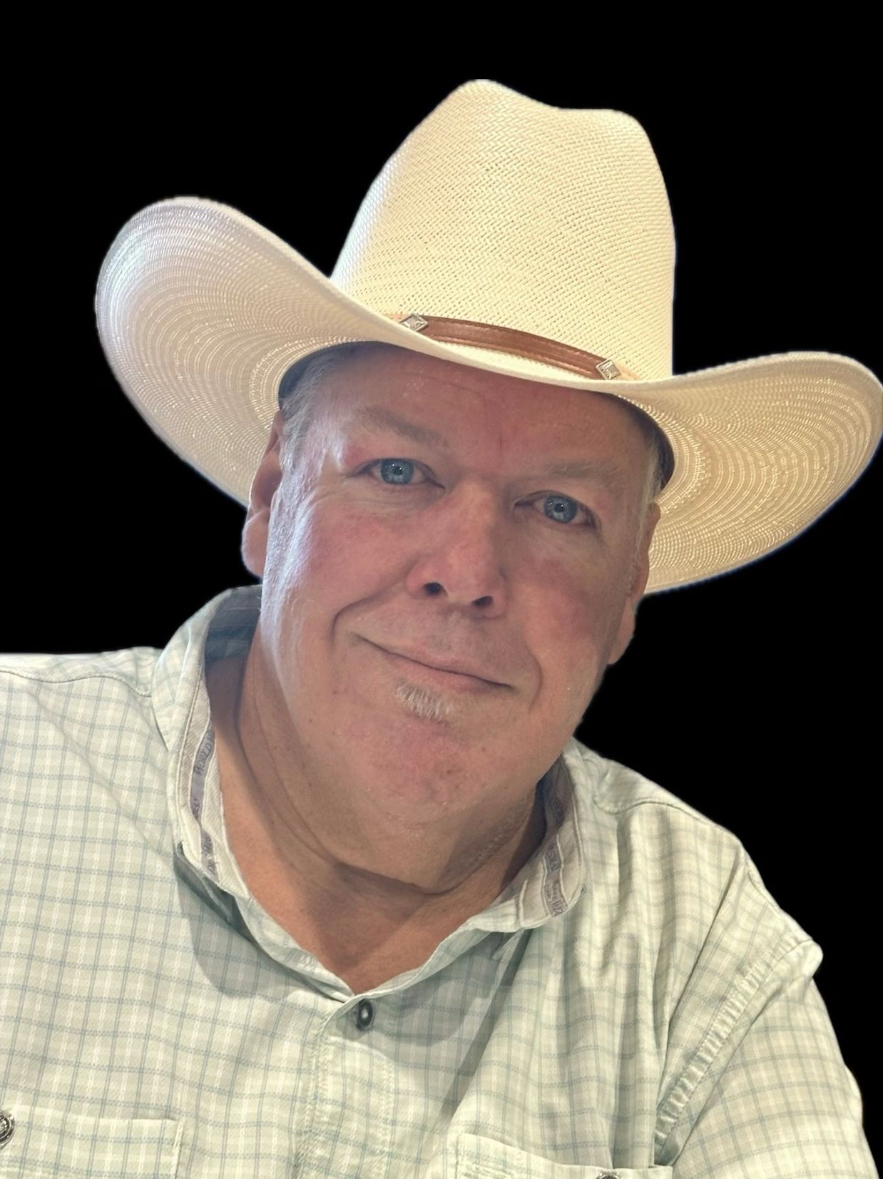 A man wearing a white cowboy hat and plaid shirt.