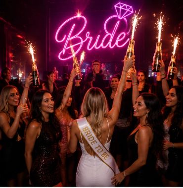 Women celebrating a bride to be with sparklers and drinks.