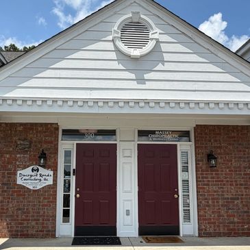 Entrance with two red doors at a chiropractic and counseling office.