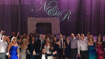 Happy Wedding party with a custom monogram in the background.