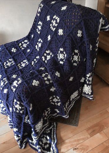 A blanket woven from white and navy yarn.