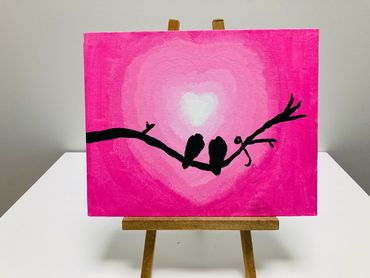 A painting of birds against a pink heart shaped background.