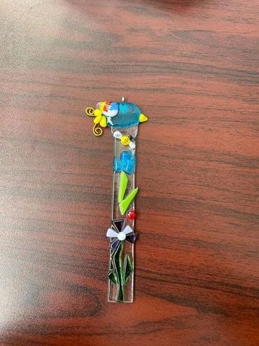 A fused glass ornament featuring flowers.