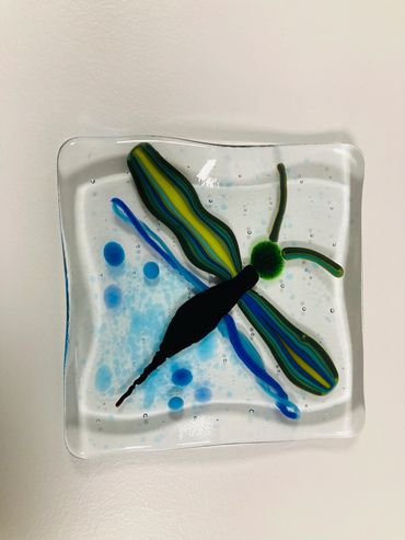 A fused glass square featuring a dragonfly.