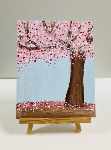 A painting of a tree with pink, red and white blossoms.