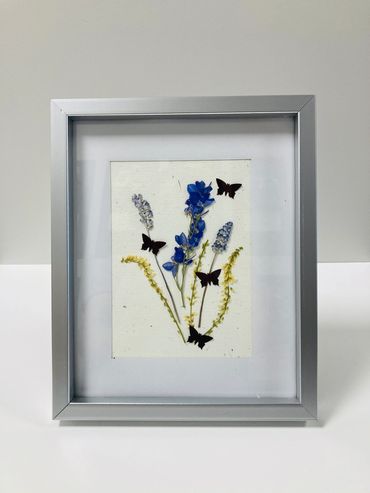 A pressed flower piece featuring butterflies and pressed flowers.
