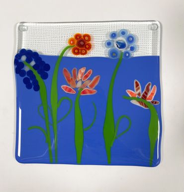 A fused glass square featuring flowers.