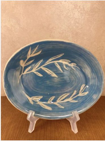 A ceramic dish featuring white vines on blue.
