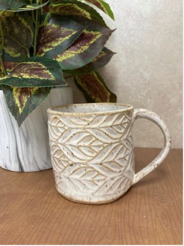 A ceramic mug featuring a leaf texture.