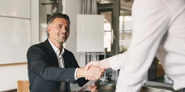 Two professionals shaking hands during a business meeting.