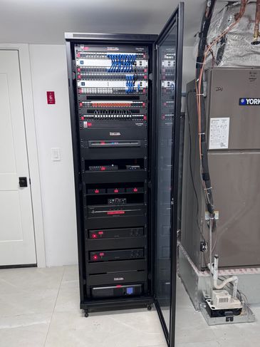 Open server rack with networking and power equipment next to HVAC unit.