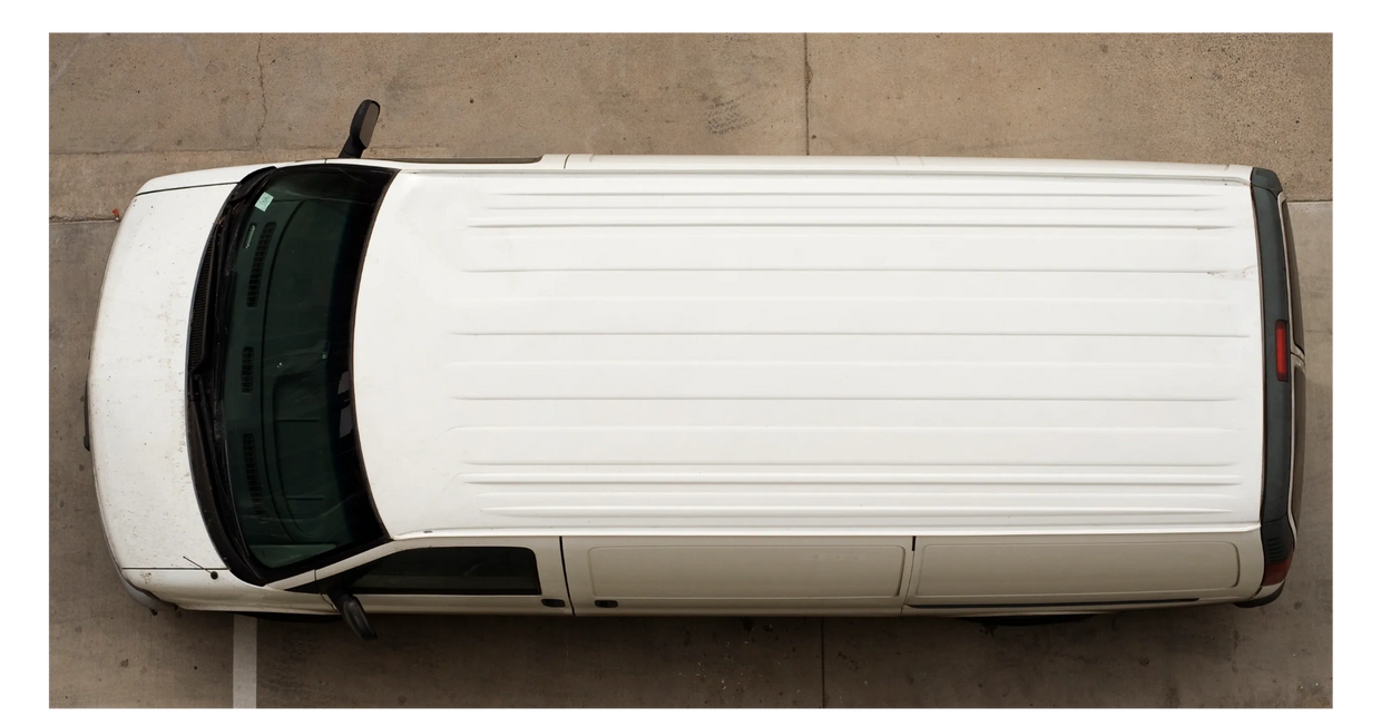 Top view of a white cargo van parked on concrete.