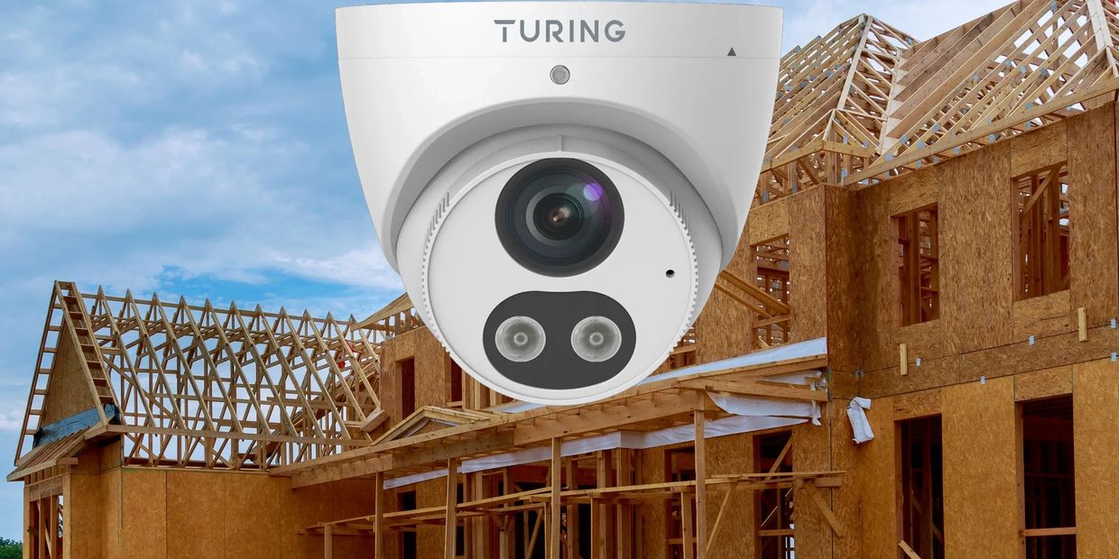 Partially constructed wooden house with a mounted security camera for new build protection.
