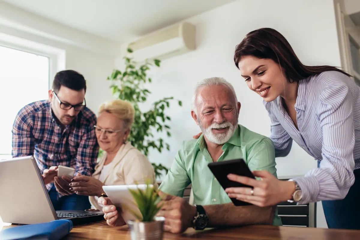 Diverse, multi-age group using tablets, smartphones, and laptops. Connect U bridges digital gaps.