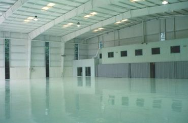 Empty large industrial warehouse with polished floor and high ceiling.