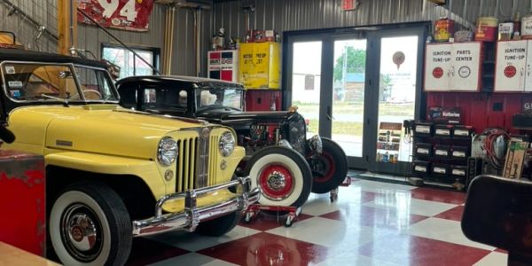 Vintage cars in a retro-style garage with checkered floor.