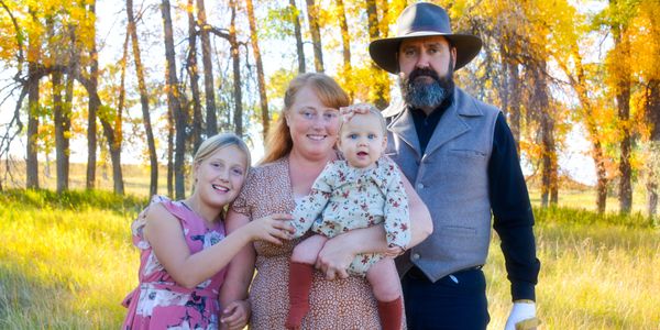 A happy family of four posing outdoors in autumn.